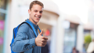 Junger Mensch zeigt Daumen hoch